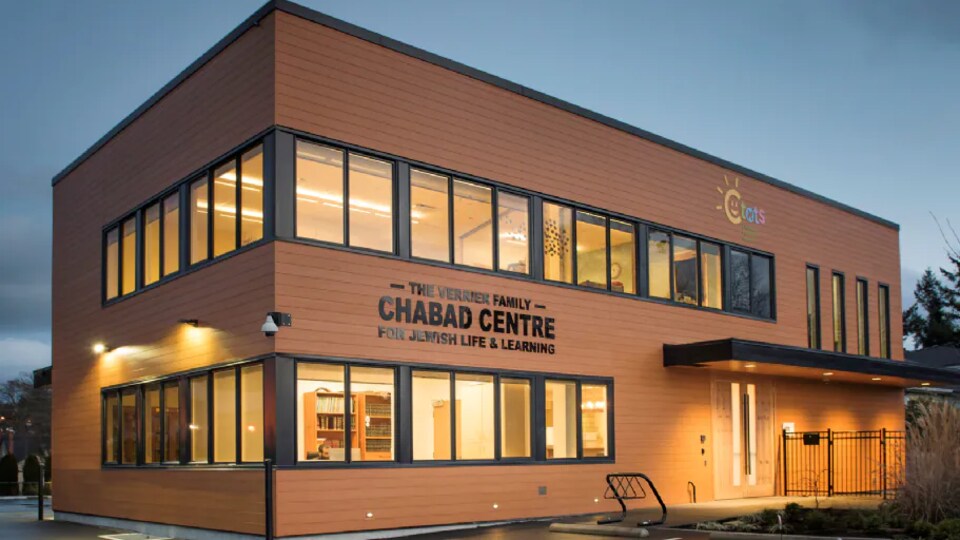 Un bâtiment rectangulaire et brun avec beaucoup de fenêtres, sur lequel il est écrit en lettres noires : Chabad Centre.