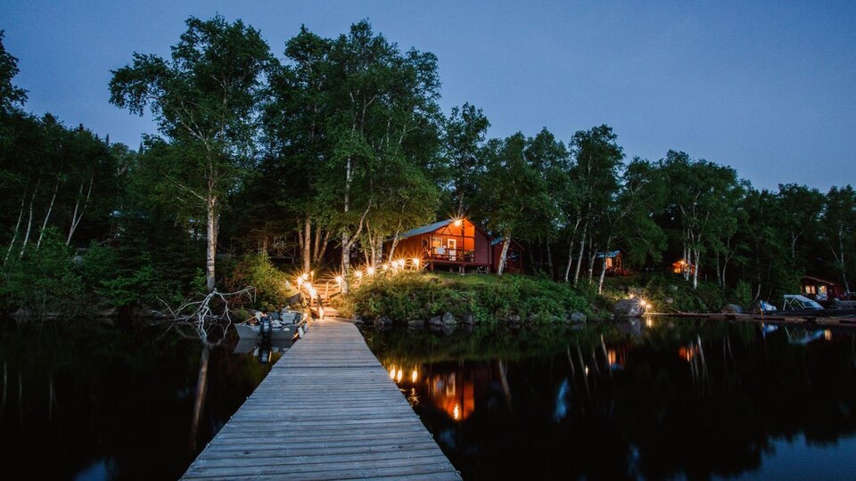 Un quai et un chalet à la pénombre.