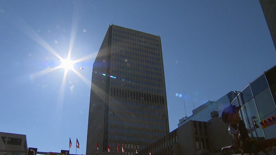Le soleil avec une tour du centre-ville de Calgary.