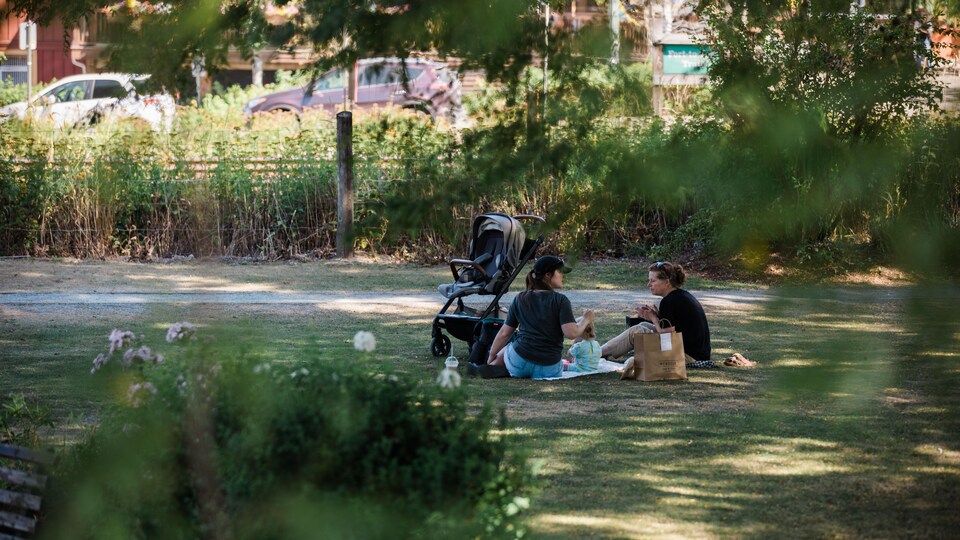 Des gens tentent de se rafraîchir à l'ombre à Fort Langley, dans la vallée du Fraser, en C.-B., le 17 août 2022.