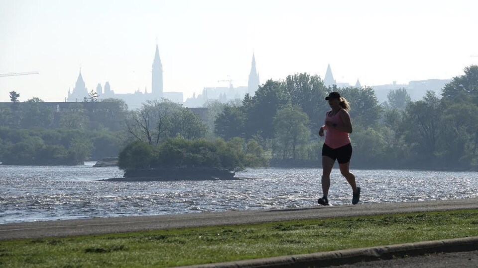 Une femme court le long de la rivière des Outaouais.