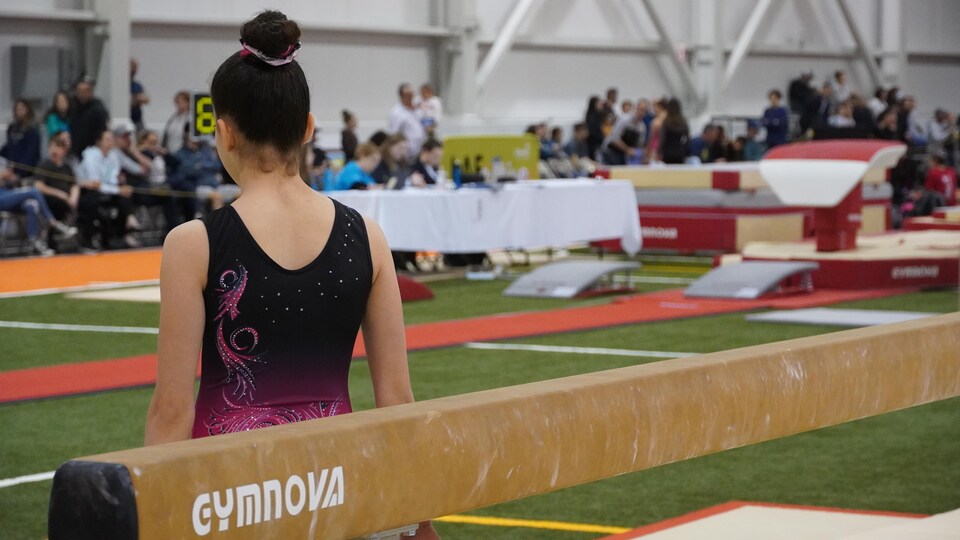 A gymnast from behind is about to start her routine during the 11th edition of the Challenge des Régions.