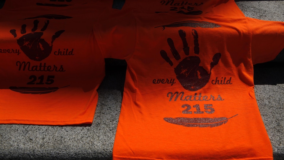 Des chandails orange sur lesquels on peut lire « Every child Matters 215 ».