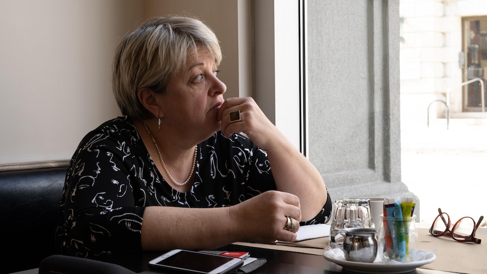 Chantal Charest is sitting at a table in a restaurant.  He was looking outside. 