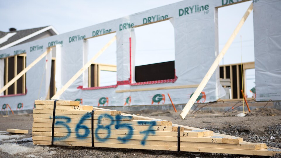 Des matériaux abandonnés près d'une maison en construction.