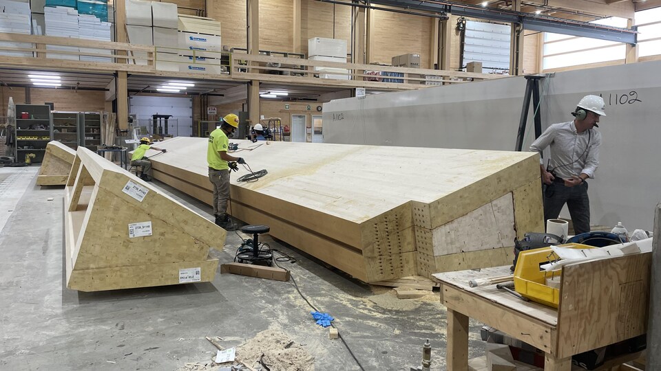Des ouvriers travaillent sur le plancher d'une usine.
