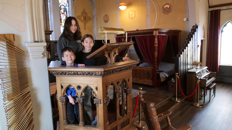 Des enfants pose sur une tribune ecclésiastique se trouve dans leur maison.