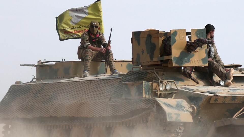 Des soldats des Forces démocratiques syriennes sur un blindé au nord de Raqqa.