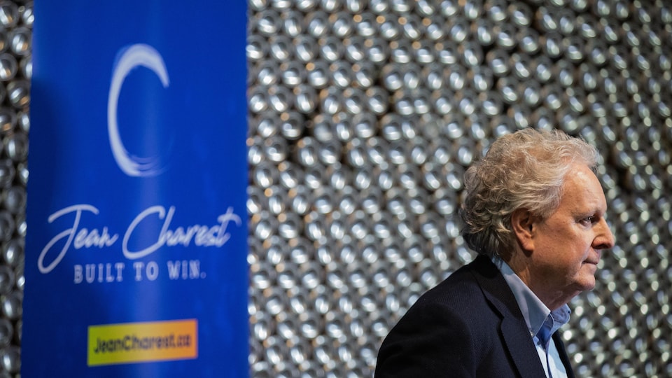 Jean Charest devant une banderole indiquant : « Jean Charest : Built to win. »