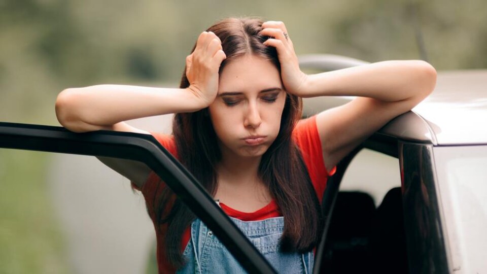 Une femme prend sa tête dans ses mains.