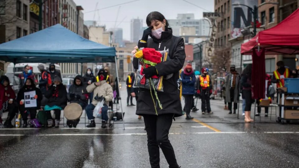 Charlene Brunelle devant d'autres manifestants masqués.