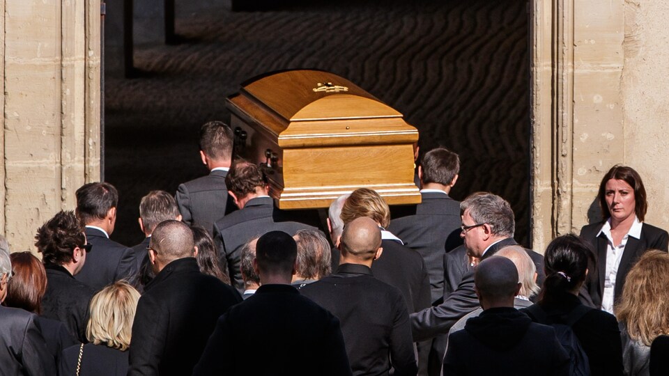 Le cercueil de Charles Aznavour porté par des hommes entrant dans l'église.