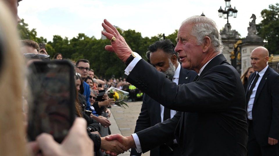 Le roi Charles III de Grande-Bretagne salue la foule à son arrivée au palais de Buckingham à Londres, le 9 septembre 2022.