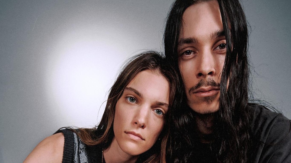 Les deux artistes posent assis.