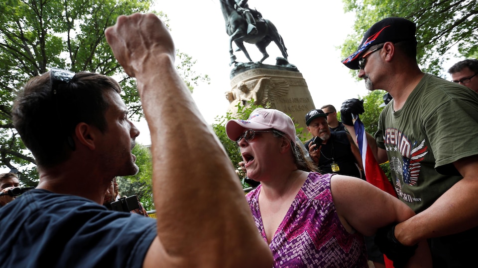 Une manifestante et un contre-manifestant s'affrontent devant la statue de Robert E. Lee à Charlottesville.