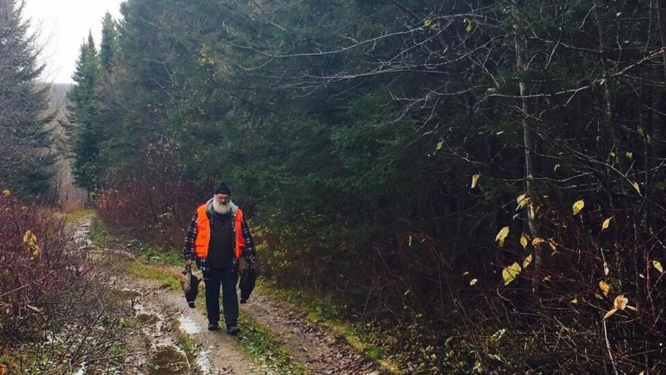 Un chasseur dans un sentier avec du gibier