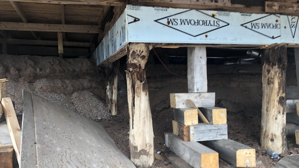 Des poutres qui soutiennent la maison au sous-sol.