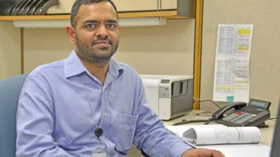 Iqbal Singh Sharma est assi devant son ordinateur avec une souris à la main
