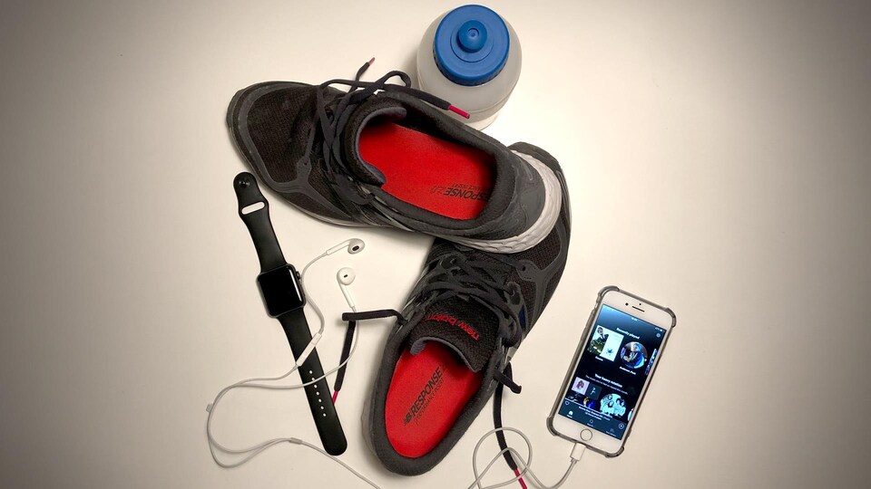 Des souliers de course, un téléphone, une montre et une bouteille d'eau.