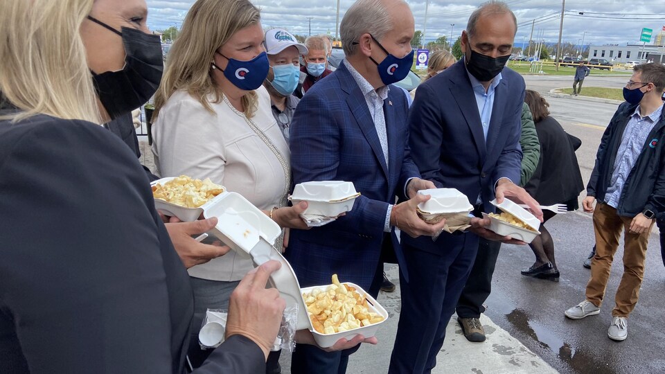 Louise Gravel, Rebecca O'Toole, Erin O'Toole et Richard Martel tiennent une poutine.