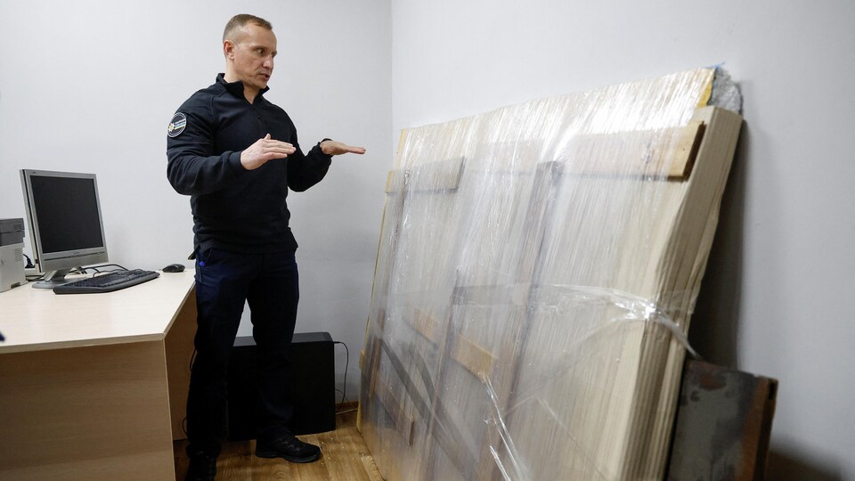 Le chef de la police régionale de Kiev montre le morceau de mur empaqueté avec l'œuvre de Bansky.
