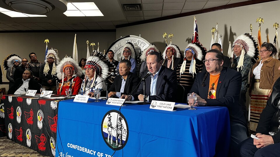 Une quinzaine de chefs autochtones parlent à une table recouverte de microphones.