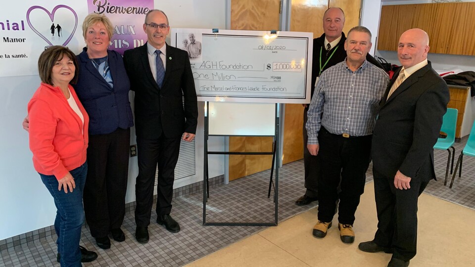 Un groupe de personnes avec un chèque d'un million de dollars.