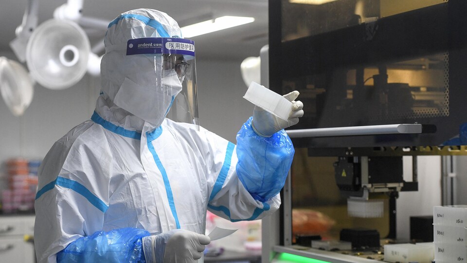 Un technicien de laboratoire chinois tient des échantillons.