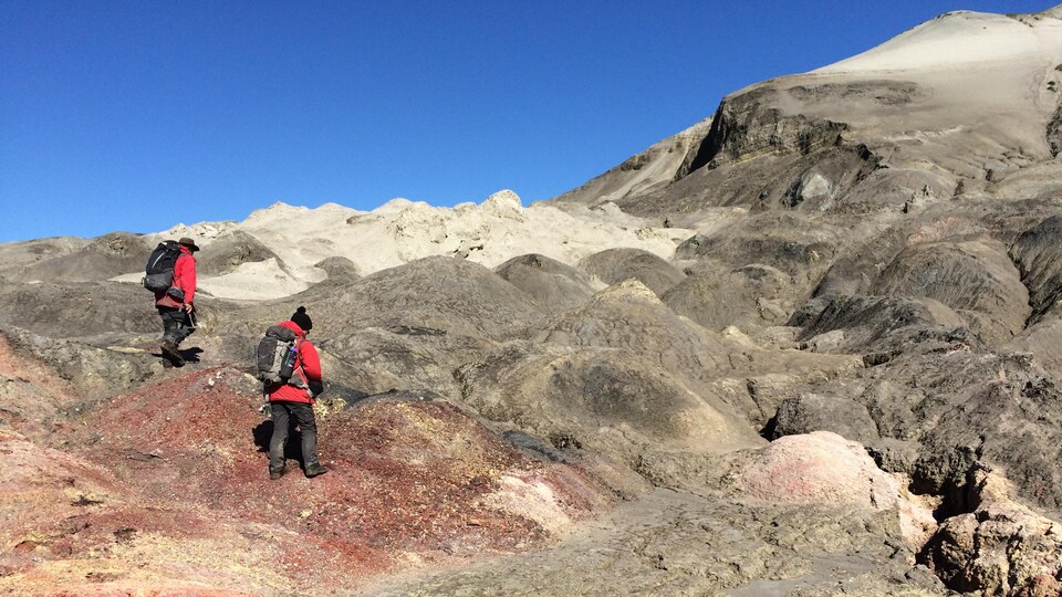 Deux chercheurs marchent sur une formation géologique aux T.N.-O.