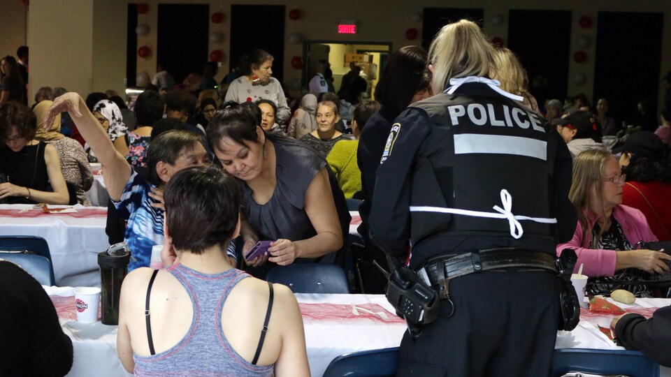 Une agente de police sert le repas à une table de femmes.
