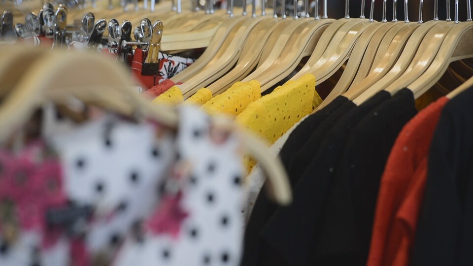 Des vêtements sont disposés sur des cintres.