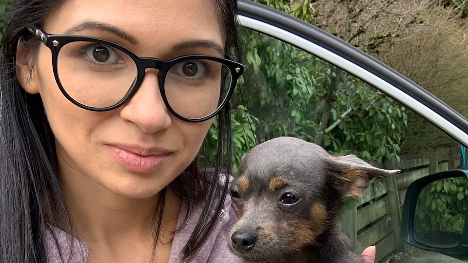 Carmela Manno pose avec un petit chien dans ses bras.