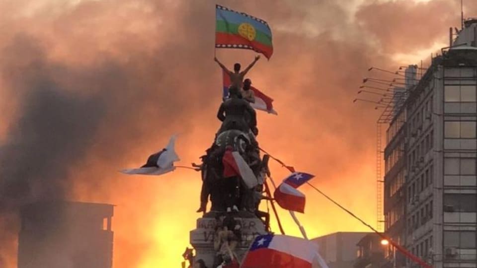 Une marre de manifestant grimpent à une statue à Santiago au Chili.