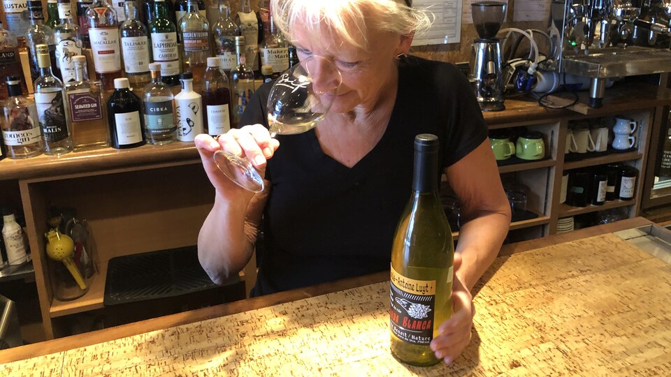 Véronique Rivest avec un verre de vin à la main.