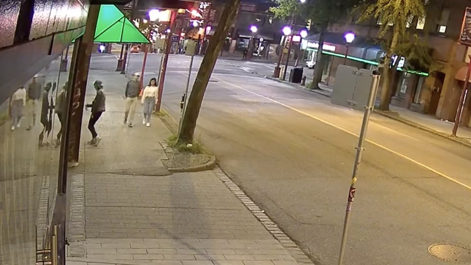 A photo from a security camera showing a man using spray paint. 