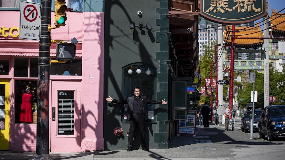 Rod Chow tend ses bras devant le bâtiment commercial le plus étroit au monde, pour démonter sa largeur.