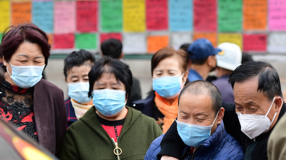 Plusieurs citoyens avec masques protecteurs en quête d'emplois dans la ville de Qingdao, dans la province de Shandong. 