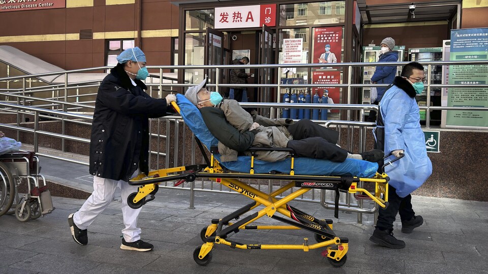 Deux infirmiers déplacent un homme sur une civière.