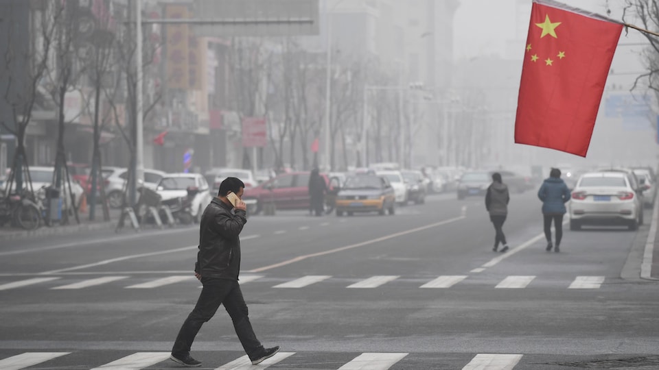 Un Chinois marche dans la rue.