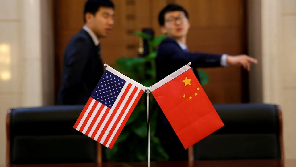 Les drapeaux des États-Unis et de la Chine installés sur une table de conférence.