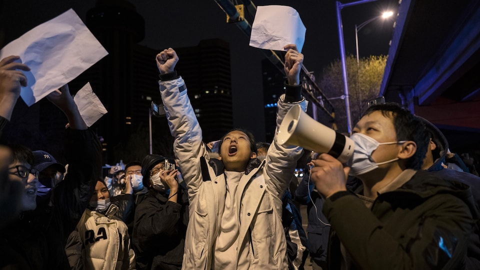 Des manifestants à Beijing, en Chine, avec des feuilles blanches dans les mains.