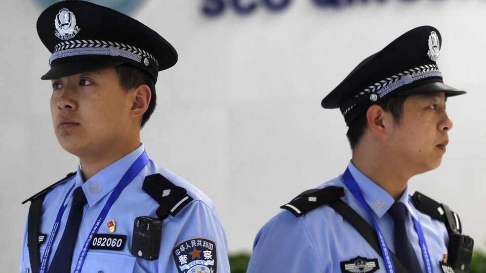 Deux agents de police chinois font de la surveillance.