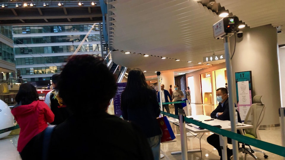 Des gens en file dans un centre commercial.