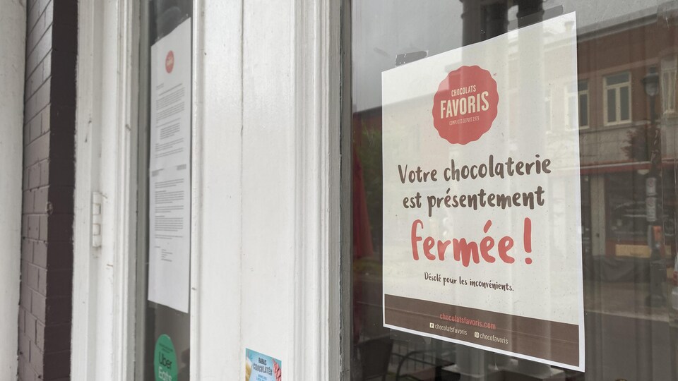 Affiche annonçant la fermeture de la chocolaterie dans la porte de l'édifice.