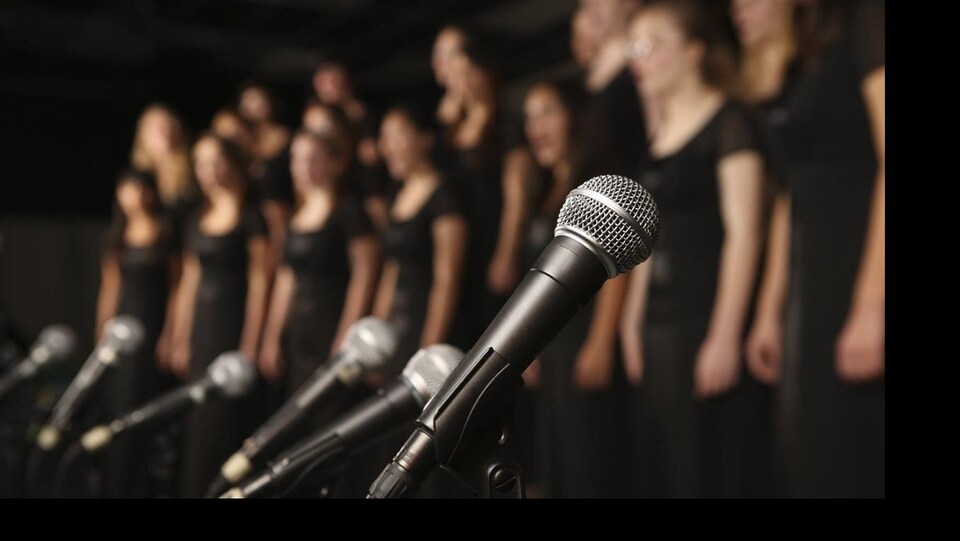 Image floue d'une chorale avec au premier plan des micros.
