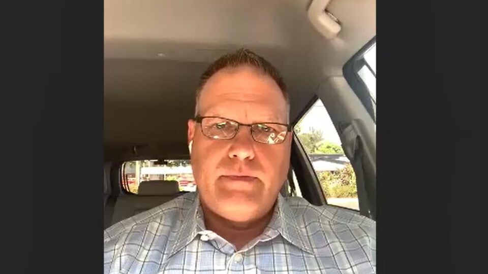 Un homme assis dans une voiture, lors d'un appel en vidéoconférence.