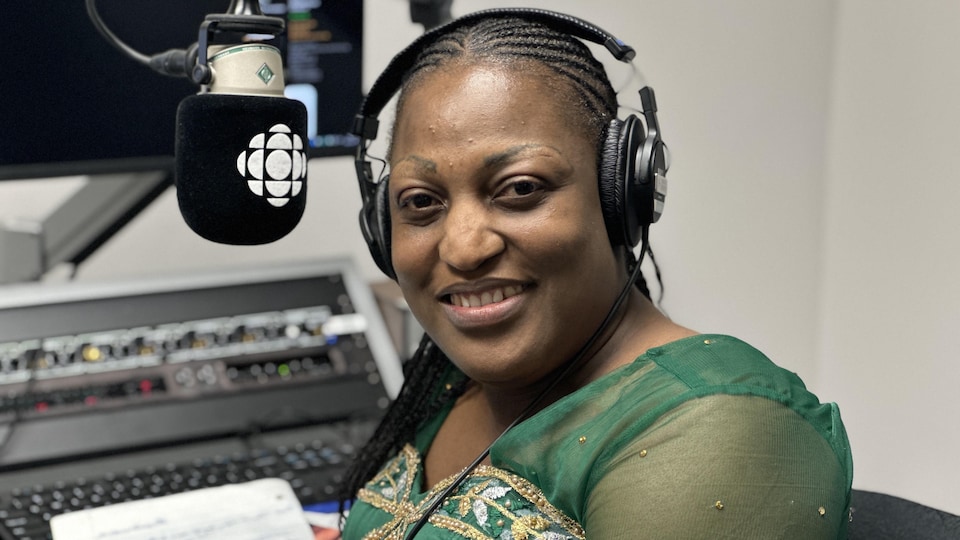 Christelle Akpoue sourit à la caméra dans un studio de Radio-Canada.