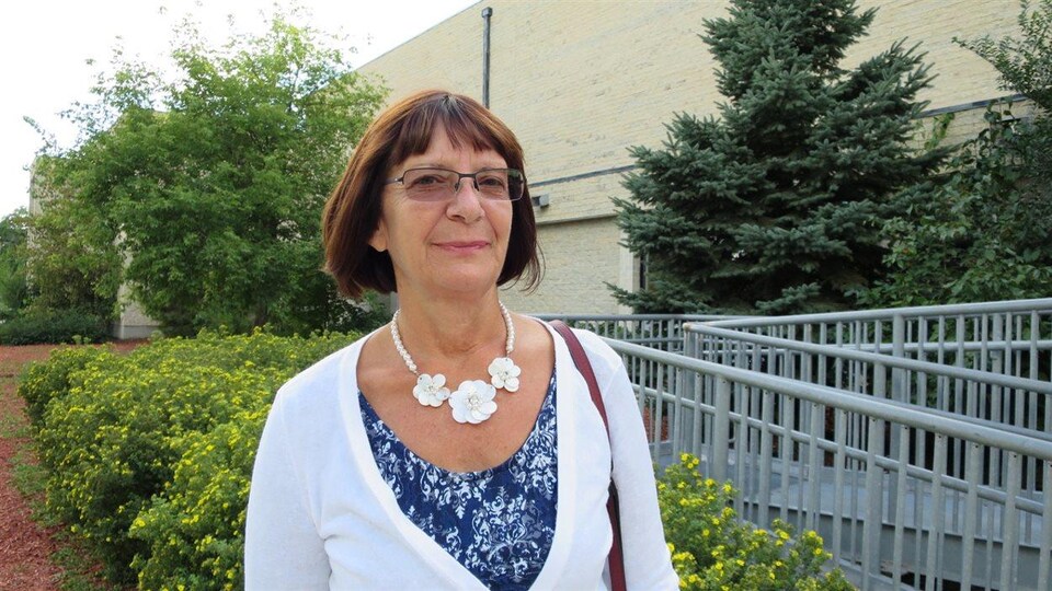 Christelle Waldie est dehors avec un chandail à manche longue et un collier. 