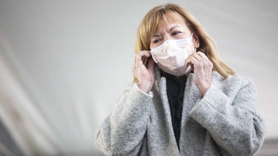 La ministre ontarienne de la Santé, Christine Elliott, ajuste son masque.