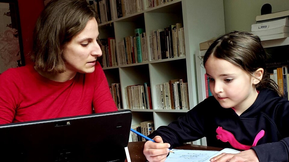 Une mère assise à une table avec sa fille.
